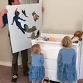 Father painting Peter pan to his children using masks and spray paint