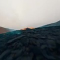 Overfly of active volcano spewing lava
